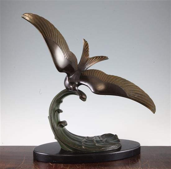 A French Art Deco patinated metal model of a sea bird on the crest of a wave, 17in.